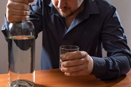 A man and a glass of vodka. Alcoholism, alcohol addiction, delirium tremens.の写真素材
