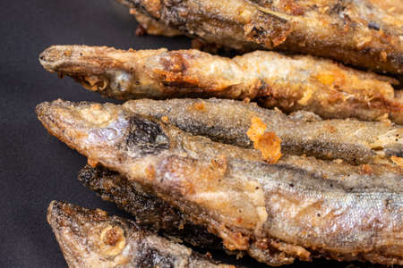 Fried capelin fish. Small fish, fried in vegetable oil in a frying pan.の写真素材
