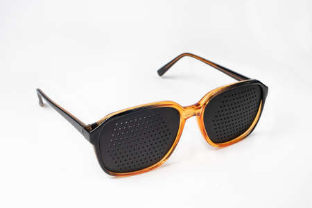 Perforated glasses with holes. Plastic glasses simulators to relieve eye strain and improve vision.の写真素材
