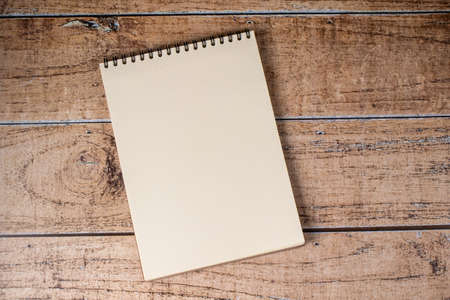White sheet page notepad on a wooden brown background. A pad on a spiral, a place for notes