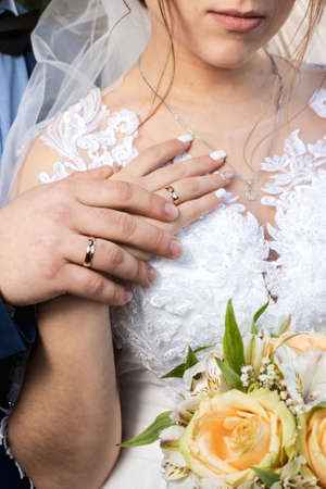 Gold rings in the hands of the bride and groom on the wedding day. Wedding and loveの写真素材