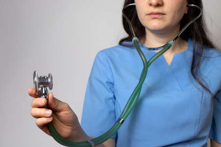 Doctor in blue uniform holds a stethoscope in his hand.の写真素材