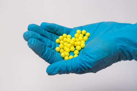 A handful of yellow vitamins in the hands of man. Dragee Vitamin C.