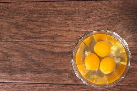 Three raw eggs in a glass bowl. The contents of chicken eggs for cooking eggs and other dishes.の写真素材