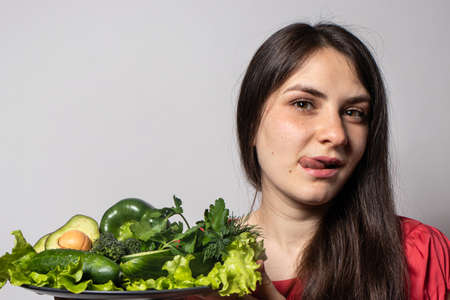 Girl and a vegetable plate. Veganism and vegetarianism. Proper nutrition, raw food diet and...