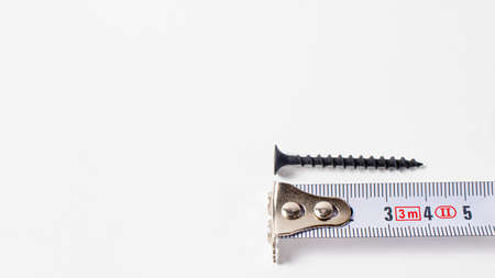 Measuring tape of roulette and self-cutting on a white background. Building tools banner with space for textの写真素材