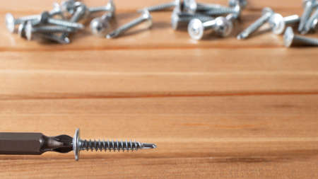 A screwdriver and self-cutters on a brown wooden background. Building tools to repair the houseの写真素材