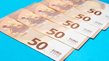 Fragment of the 50 fifty euro banknote on a blue background. Close up currency money.の写真素材