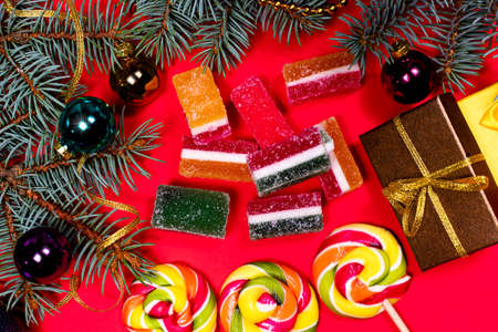 Leneds on a stick and marmalade on a red background. Banner for confectionery with Christmas decorations.の写真素材