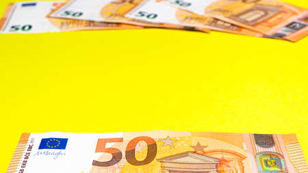 Fragment of the 50 fifty euro banknote on a yellow background. Close up currency moneyの写真素材