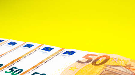 Fragment of the 50 fifty euro banknote on a yellow background. Close up currency money. Place for text. Copの写真素材
