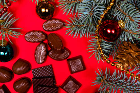 Chocolates on a red background. New Years 2021 decor and chocolate, candy - festive photo for confectionery.の写真素材