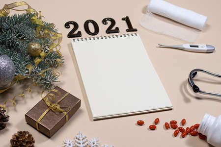 New Year's card on medical subjects: figures 2021, phonendoscope, tablets, thermometer and bandage...