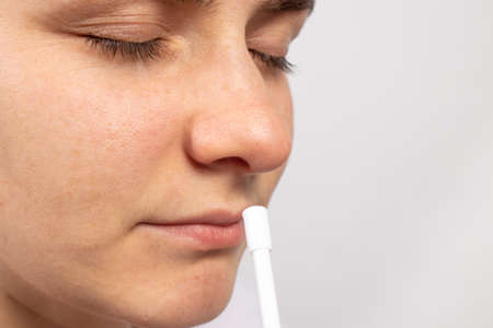 A man splashes in the nose medicine for snot and runny nose. Medicine and pharmacy, the treatment of rhinitis with local for copyspace text.の写真素材