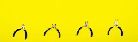 The electrician's tools on a yellow background pliers, tongs, rounds and cutters. Long banner for the building materials store.の写真素材