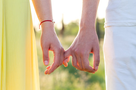 Men's and women's hands of lovers, two men gently hold hands. Love forever, touch and romanceの写真素材