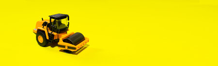 Children's toy typewriter skating rink roller machine on a yellow background. Photo for a toy store with a place for copy space text. Truck tractor for the boy.の写真素材