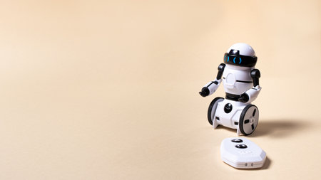 A robot with a remote control on beigeの写真素材