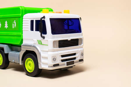 The toy is a garbage truck green with a white body on a beige banner with a place for text for a toy...