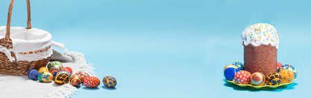 A congratulatory blue banner with an Easter cake, a basket and eggs with place for text.の写真素材