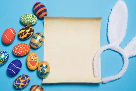 Beautiful Easter photo with eggs and bunny ears with parchment paper for text.on a light minimalist...