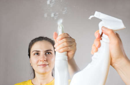 The cleaning lady cleans the mirror with a water dispenser and window cleaner. House cleaning. Cleaning serviceの写真素材