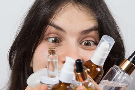 A woman holds many jars of cosmetics after a sale in a cosmetics store. Special offer and discounts...