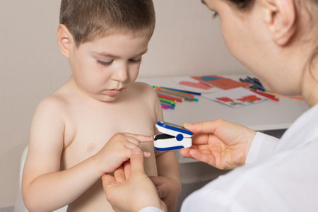 The pediatrician measures the childs blood oxygen level with a pulse oximeter. Pneumonia and in childrenの写真素材