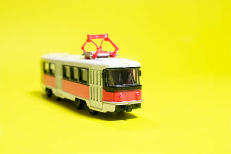 Childrens toy red white tram on a yellow background copy space for text. Toys for a toy store, cars for a boy.の写真素材