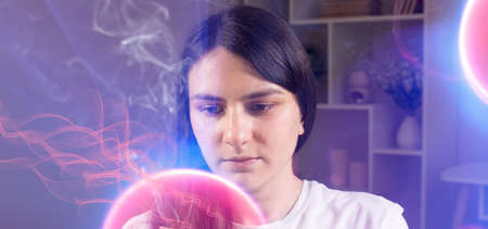 A concentrated woman looks at the pink burning ball. Quantum theory of man, consciousness and...