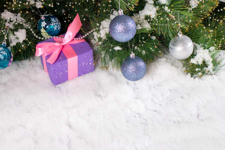 A gift for Christmas in the snow under the tree with space for the text