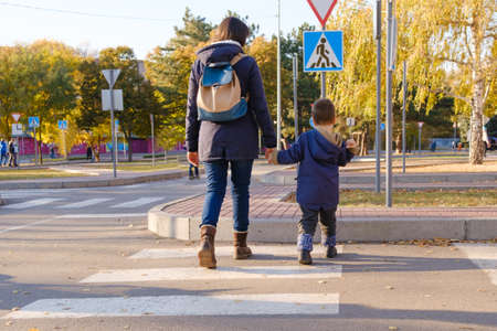 Mom and child cross the road at the zebra crossing.の写真素材