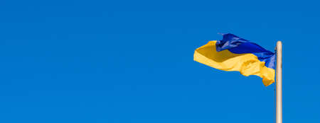 Ukrainian flag of yellow and blue colors branches in the wind against the sky.の写真素材