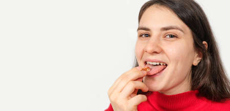 A woman takes an omega 3 capsule on a white background, a banner with a place for text