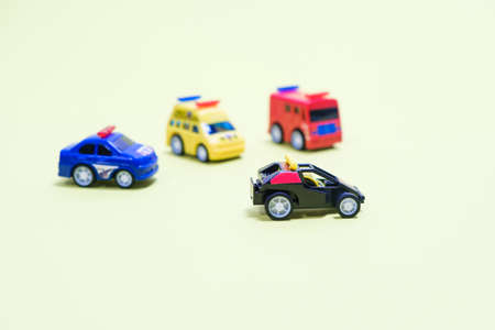 Toy plastic little cars on a light yellowish background with a place for text. Toys for childrenの写真素材