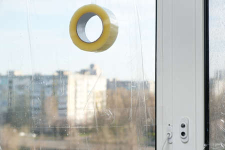 Sealing the windows with adhesive tape during the war in Ukraine to prevent the formation of many...