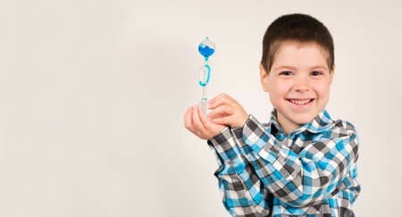 A 4-year-old boy is studying chemistry, holding in his hand a flask with a blue liquid that moves...