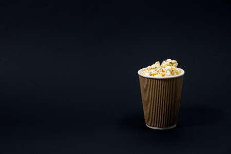 Popcorn in a glass on a black background with space for text.の写真素材
