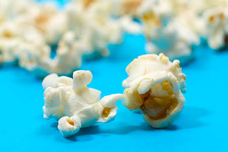Macro photo of popcorn, corn kernels on a blue background.の写真素材