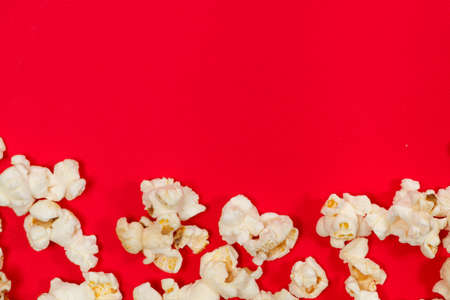Popcorn on red background, top view with space for text.