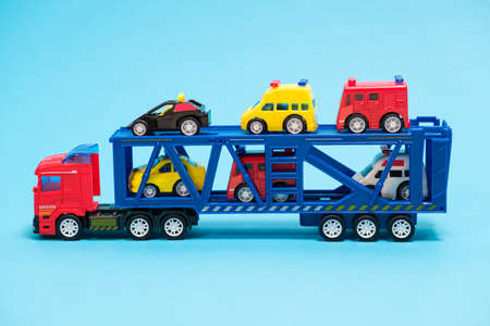 Toy car transporter with cars on a blue background, for a toy store.の写真素材