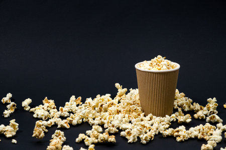Popcorn in a glass on a black background with space for text.