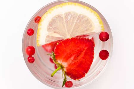 Summer refreshing cocktail with strawberries, berries, lemon and ice, top viewの写真素材