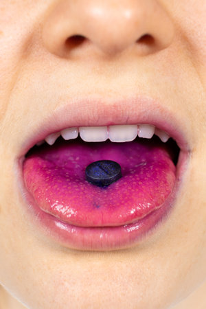A person shows an indicator pill on his tongue to determine plaque