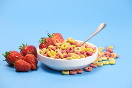 Quick breakfast cereal - rings with milk and strawberries on a blue background