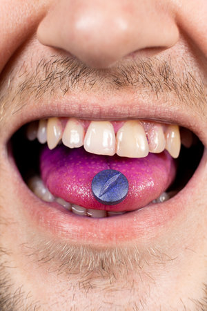 A person shows an indicator pill on his tongue to determine plaque.の写真素材