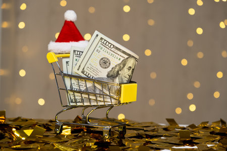 Christmas cart with dollar money and Santa Claus hat, winter holiday saleの写真素材