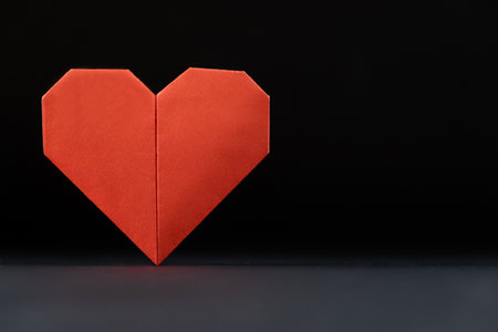 Origami for Valentine's Day - red paper heart on a black background do it yourself, DIY, place for text, copy space.の写真素材