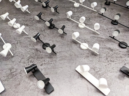 Lots of white and black lamps on the wall. Electrical goods, chandeliers, electric light store.