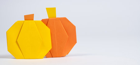 Halloween DIY Origami - Yellow and Orange Paper Pumpkins on a White Background.の写真素材